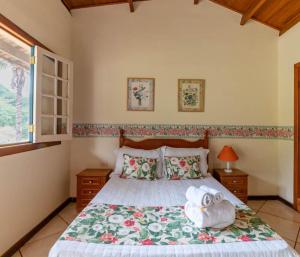 a bedroom with a bed with two towels on it at Hotel Fazenda Santa Helena in Simão Pereira