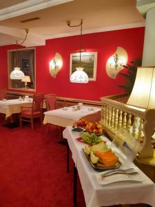 a restaurant with white tables and red walls at Schedlers Löwenhotel-GARNI in Alberschwende