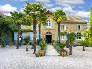 une maison avec des palmiers devant elle dans l'établissement Maison Manechal, à Monfaucon