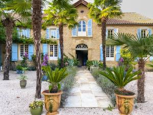 une maison avec des palmiers devant elle dans l'établissement Maison Manechal, à Monfaucon