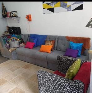 a living room with a couch with colorful pillows at Hospedaria da Mama in Sao Paulo