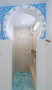 a bathroom with a shower with blue tiles at Guru Canggu in Canggu