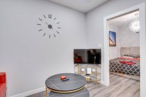 Zimmer mit einem Tisch und einer Uhr an der Wand in der Unterkunft Modern & Private 1-Bedroom Apartment in Windsor