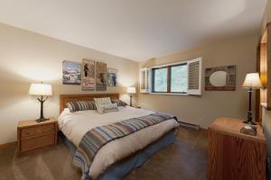 a bedroom with a bed with two lamps and a window at Cascade Village 48 in Durango Mountain Resort
