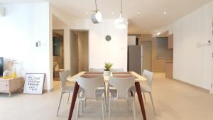 uma cozinha e sala de jantar com uma mesa de madeira e cadeiras em KLGateway Premium Residence Mid Valley em Kuala Lumpur