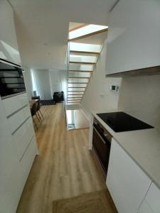 una cocina con una escalera que conduce a una sala de estar. en Casa Aveiro Modern House en Aveiro