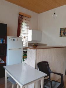 a kitchen with a white table and a white refrigerator at Muse House in Ambrolauri