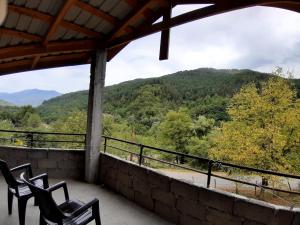 a balcony with chairs and a view of a mountain at Muse House in Ambrolauri