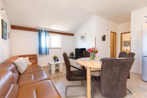 a living room with a couch and a table at Apartments House Risika in Risika