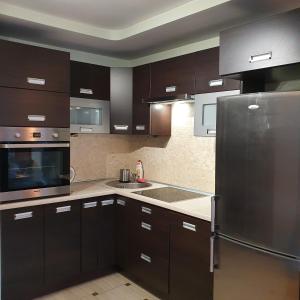 a kitchen with brown cabinets and a stainless steel refrigerator at Center Apartment in Warsaw