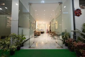an office corridor with glass walls and plants at Poornima Regency in Bangalore