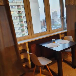 a table and chairs in a room with windows at Center Apartment in Warsaw