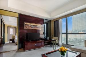 a living room with a television and a large window at Crowne Plaza Shenzhen Longgang City Centre, an IHG Hotel in Longgang