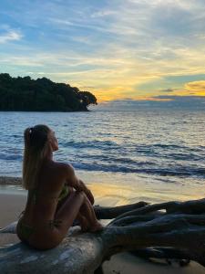 a woman sitting on the beach watching the sunset at Island Paradise, Saboga Lodge and Villa Noelia in Panama City