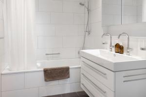 a white bathroom with a sink and a tub at Pranursa in Arosa