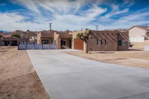 a home in the desert with a building at THREE TREE VILLA w/ EV Charging in Yucca Valley