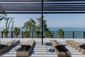 a building with benches and a view of the ocean at House at the Sea in Batumi