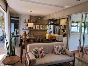 Casa Dharma - Conforto e Silêncio في ألتو بارايسو دي غوياس: غرفة معيشة مع أريكة ومطبخ
