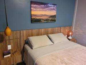 Casa Dharma - Conforto e Silêncio في ألتو بارايسو دي غوياس: غرفة نوم بها سرير ولوحة على الحائط