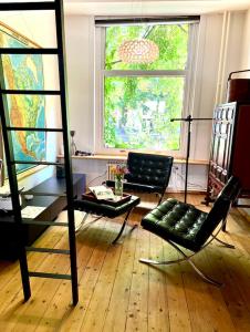 uma sala de estar com cadeiras, uma mesa e uma janela em La bellétage by Agelandkaai be with Free Parking em Gent