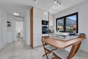 eine Küche mit einem Tisch und Stühlen sowie einem Fenster in der Unterkunft Apartment Nizza in Makarska