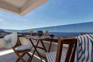 einen Balkon mit einem Tisch und 2 Gläsern Wein in der Unterkunft Apartment Nizza in Makarska