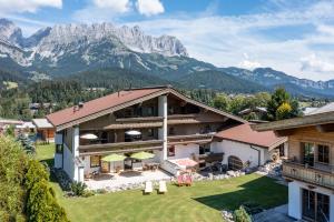 an exterior view of a house with mountains in the background at Eden Appartements in Going am Wilden Kaiser