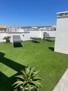 a yard with two chairs and a plant on a roof at Apartamento de lujo con piscina en Tarifa in Tarifa