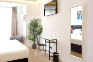 1 dormitorio con espejo, escritorio y cama en Woohoo Rooms Boutique Gran Vía en Madrid