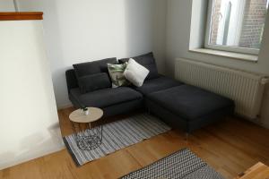 a black couch in a living room with a table at Ferienhaus Erna in Doberlug-Kirchhain