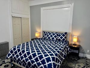 een slaapkamer met een blauw en wit bed en 2 lampen bij 3 bedrooms 2 stops to Manhattan in Long Island City