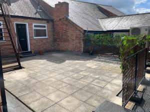 a patio in front of a brick house at Lovely 2 bed Apartment, Arnold Town centre. in Nottingham