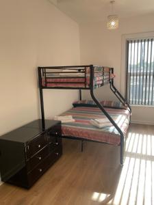 a room with a bunk bed with a dresser and a window at Lovely 2 bed Apartment, Arnold Town centre. in Nottingham