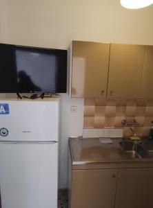 a kitchen with a refrigerator and a tv on the wall at Olympus apartments 3 in Leptokaria +5 photos
