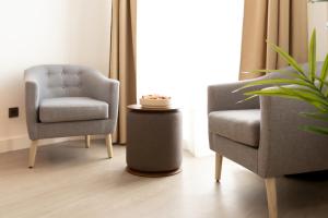 - un salon avec deux chaises et une table dans l'établissement Woohoo Rooms Boutique Gran Vía, à Madrid