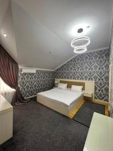 Schlafzimmer mit einem Bett und einem Kronleuchter in der Unterkunft Hotel Afrosiyob in Qarshi