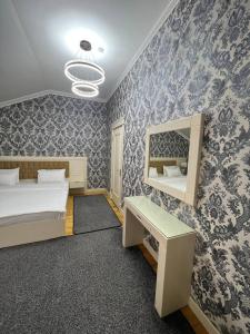 1 dormitorio con cama, escritorio y espejo en Hotel Afrosiyob, en Qarshi