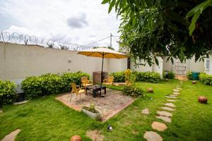 ロメにあるVilla Damasの庭園内のパティオ(テーブル、傘付)