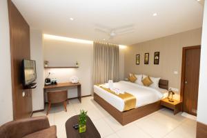 a hotel room with a bed and a television at Poornima Regency in Bangalore