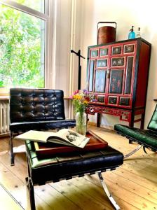 uma sala de estar com um sofá, uma mesa e cadeiras em La bellétage by Agelandkaai be with Free Parking em Gent