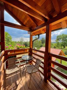- une terrasse couverte en bois avec 2 chaises et une table dans l'établissement Vénusz Üdülőcentrum, à Tiszacsege