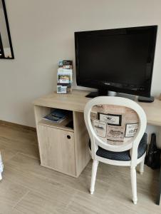 een bureau met een tv en een stoel in een kamer bij L'Atelier Saint-Sulpice entre Bordeaux et St Emilion in Saint-Sulpice-et-Cameyrac