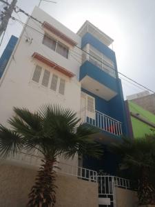 a building with a palm tree in front of it at Apartamento Casa hollanda in Mindelo