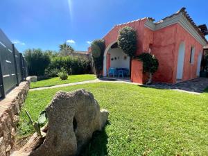 uma casa com um jardim de relva em frente em Villa Antonella em San Teodoro