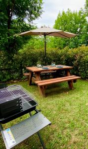 a picnic table with an umbrella and a grill at Chalet Casa La Cumbrecita en Panticosa in Panticosa