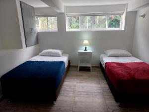 two beds in a room with two windows at Finca Mirador del Cielo Tena, Cundinamarca in Tena