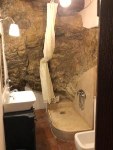 a stone bathroom with a sink and a shower at La Casa nel Castellare in Campiglia dʼOrcia +49 photos
