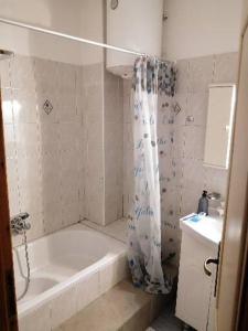 a bathroom with a bath tub and a sink at Samos House in Samos