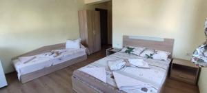 two beds in a room with two tables and two beds sidx sidx sidx at Guest House Proynovi in Kalofer