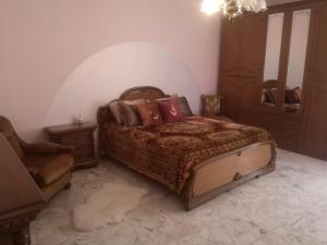 a bedroom with a bed and a chair and a mirror at Casa vacanze Sofia in Irsina